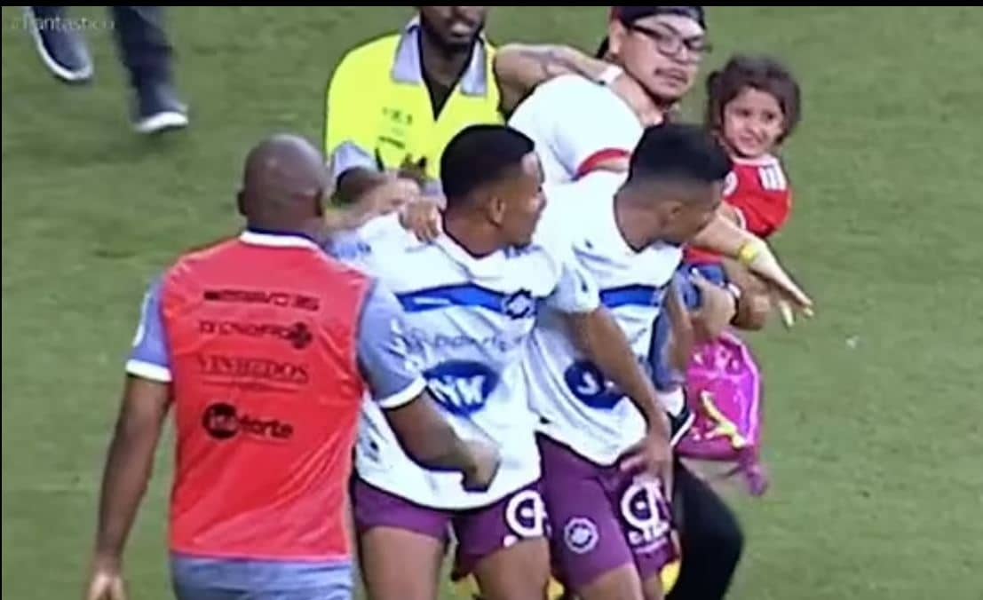 Shocking: Brazilian football match interrupted as father storms pitch with child to assault player