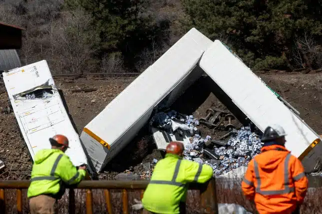 Train derails into a river, spilling hundreds of crates of alcohol