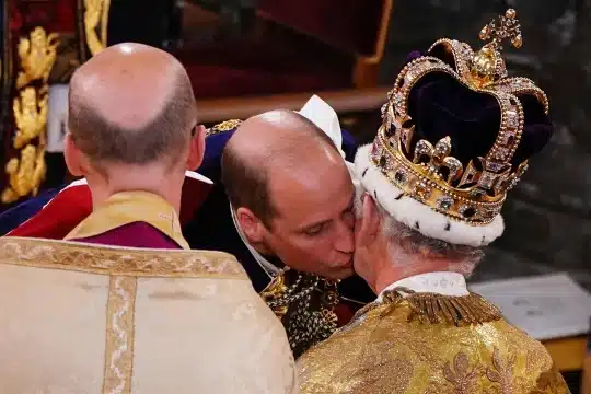Prince William kisses his father during coronation
