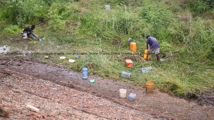 Residents illicitly extract fuel from a tanker that overturned on the Tema-Accra motorway
