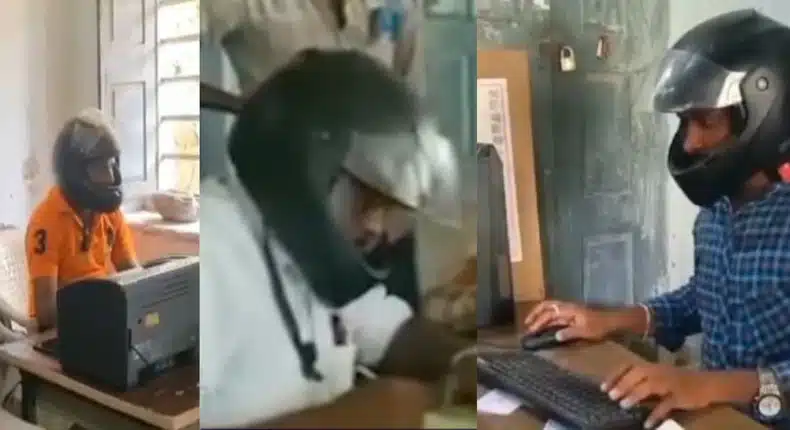 Workers in India don motorcycle helmet in office as protection against falling debris